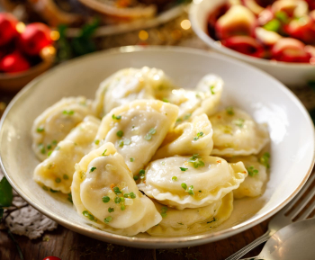 Wigilijne pierogi z kapustą i grzybami na talerzu.